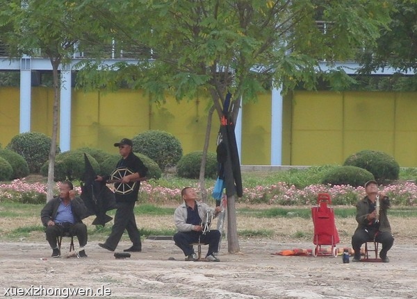 Chinesische Männer bei ihrem Hobby Drachen steigen lassen